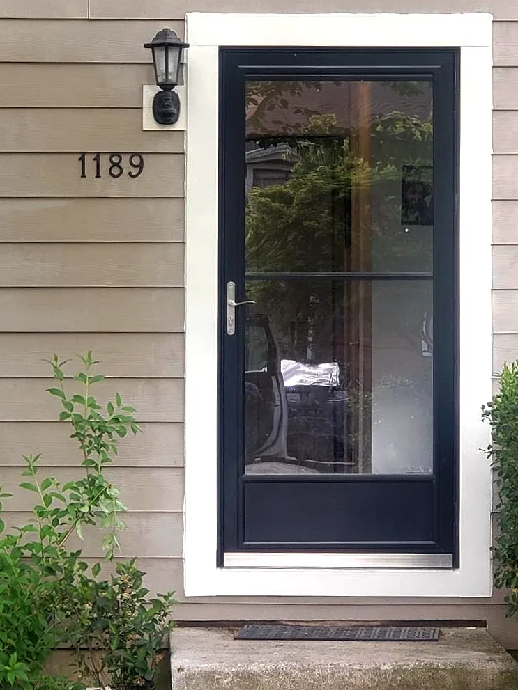 Black full-view storm door hung on a freshly painted white casing